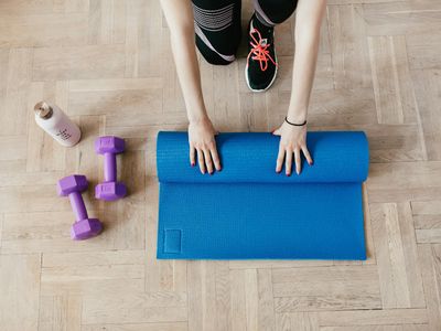 Yoga mat and a bottle of water on a dark floor.